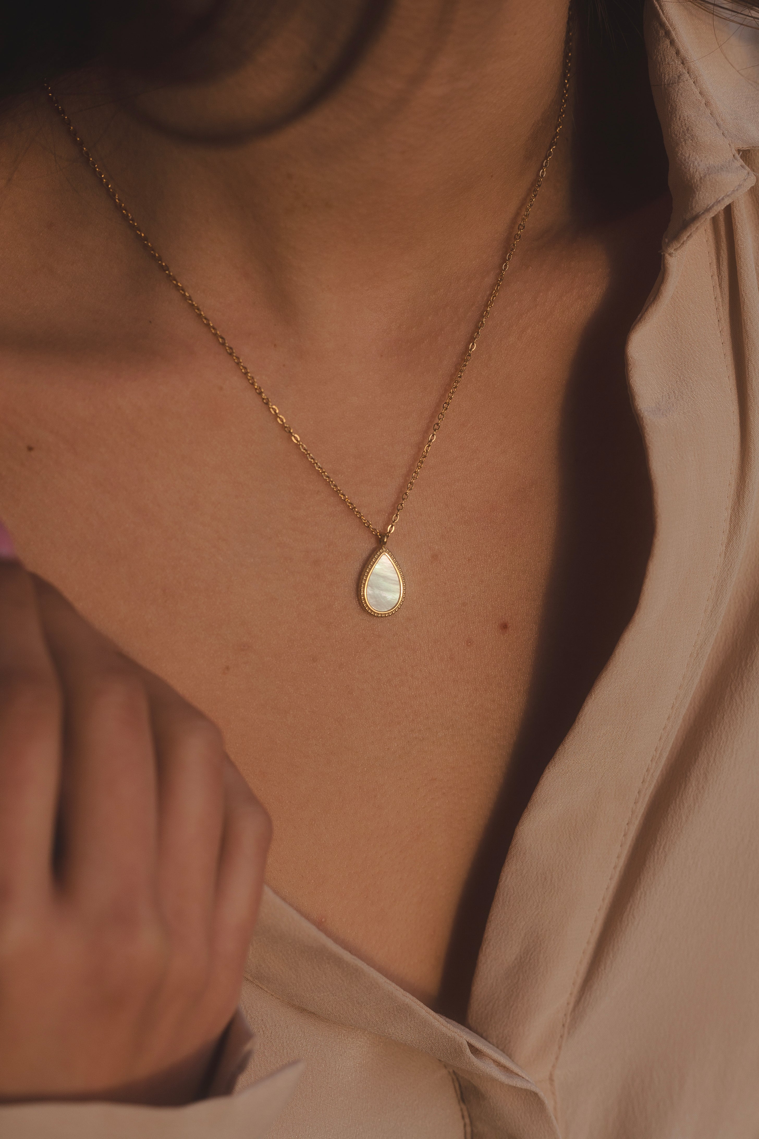 Collar dorado con colgante en forma de lágrima de nácar